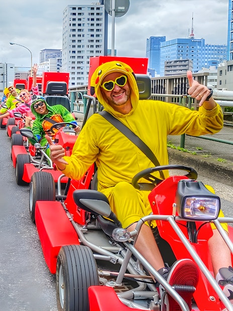 Participants in costumes enjoying street go-karting at Tokyo Bay.