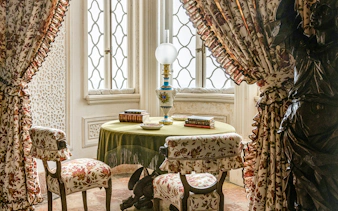 Table with books and lamp in a decorated room, Pena Palace, Portugal.