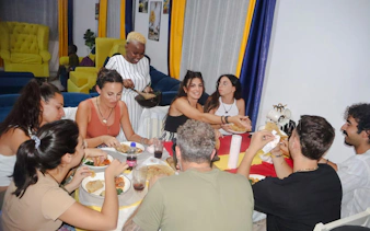 Group enjoying a meal during a cooking class with a local at Diani Beach.