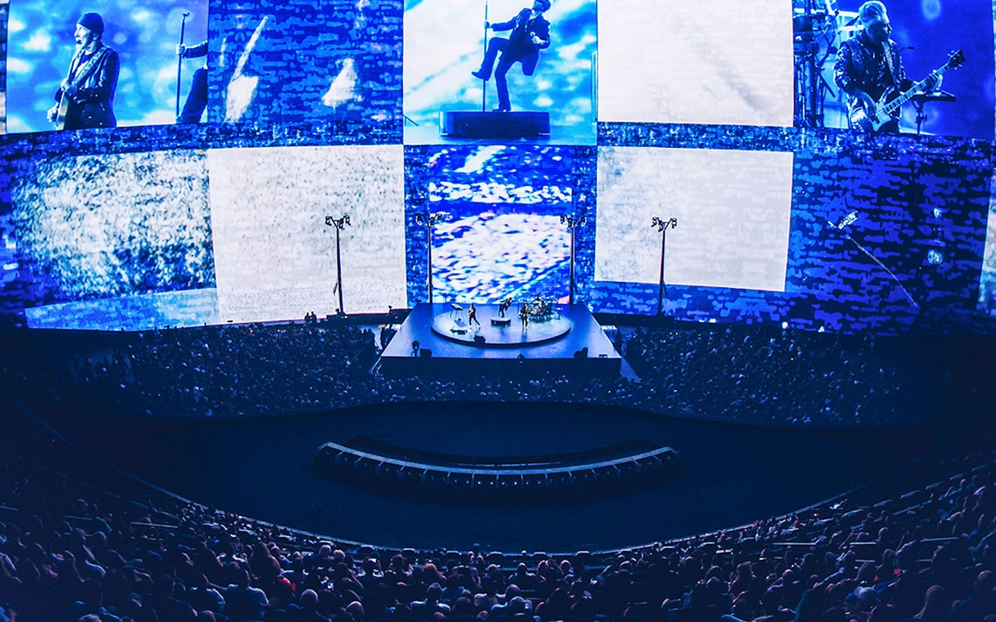 Concert at Sphere Las Vegas with band performing on stage, immersive visuals surrounding audience.
