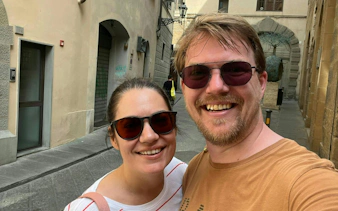Couple exploring narrow street in Florence during self-guided detective mystery game.
