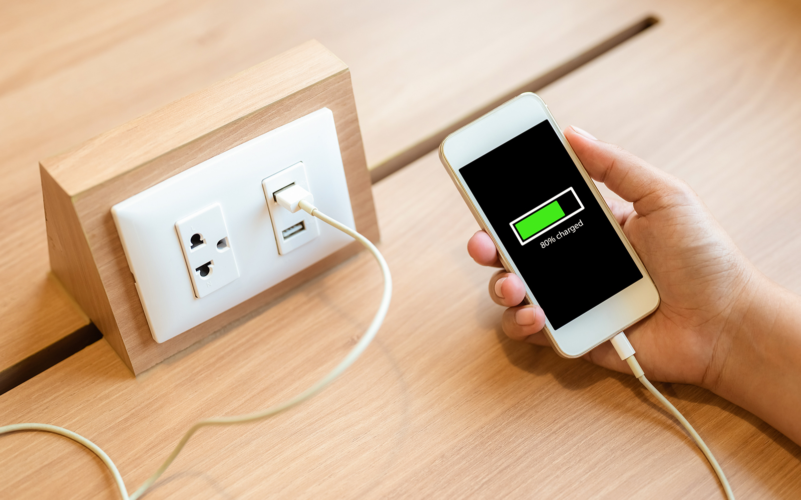 Woman charging her phone on a table
