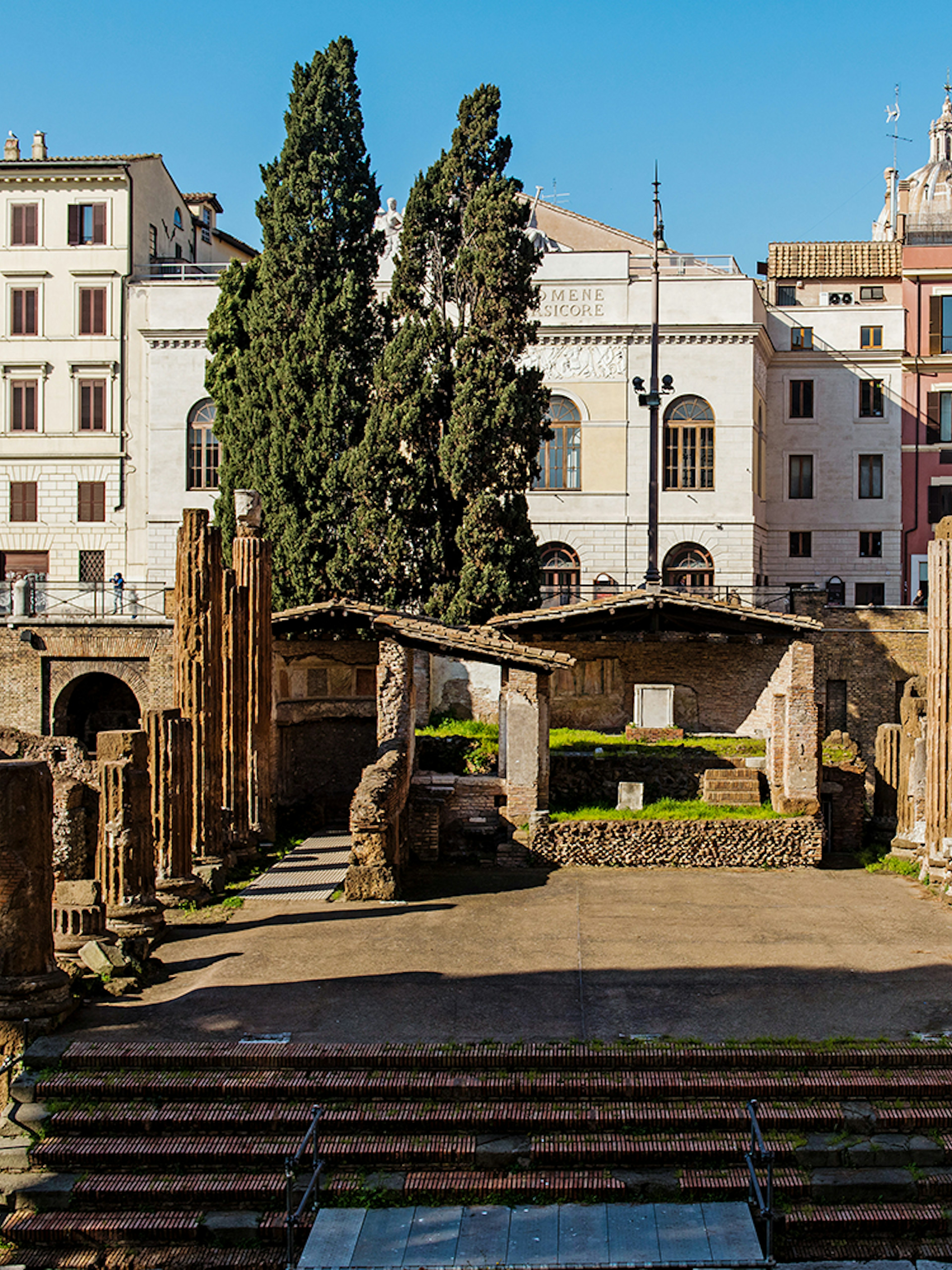 Largo di Torre Argentina ruins in Rome with ancient columns and surrounding buildings.
