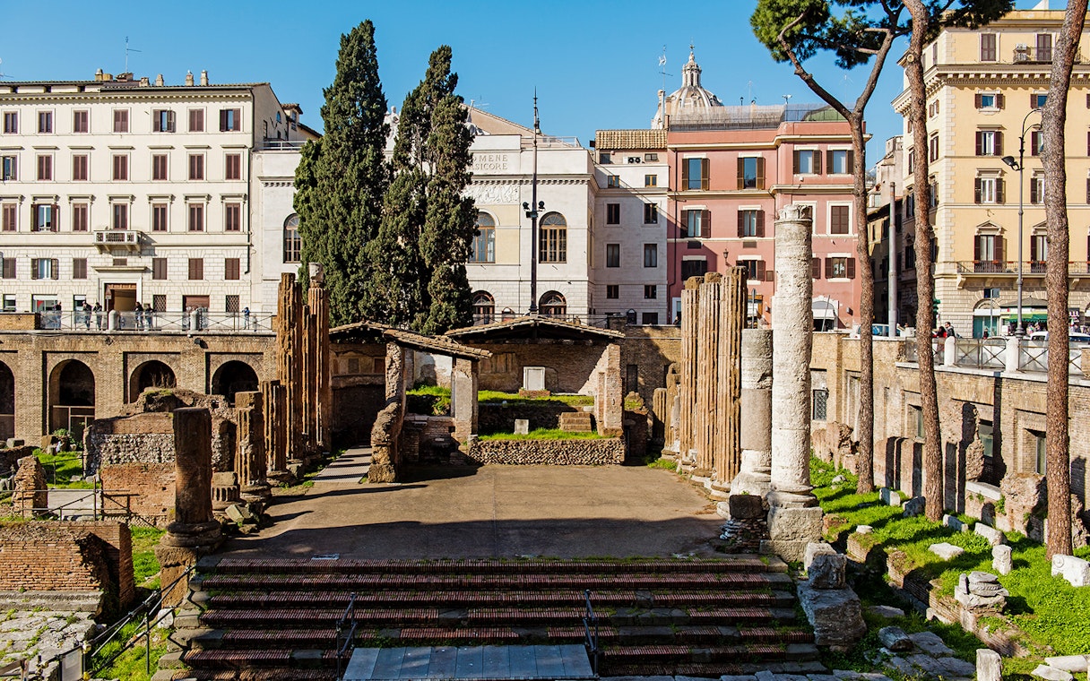 Largo di Torre Argentina ruins in Rome with ancient columns and surrounding buildings.