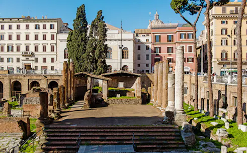 Largo di Torre Argentina ruins in Rome with ancient columns and surrounding buildings.