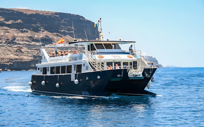 Gran Canaria cruise boat with tourists on dolphin watching experience.