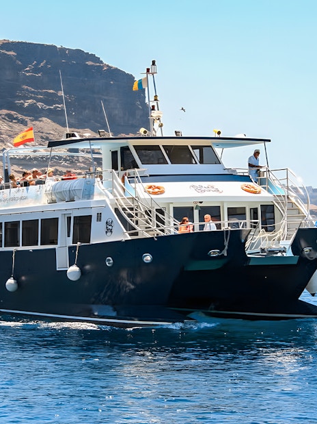 Gran Canaria cruise boat with tourists on dolphin watching experience.
