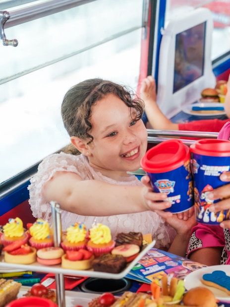 Kids and parents enjoying snacks aboard the Paw Patrol bus.