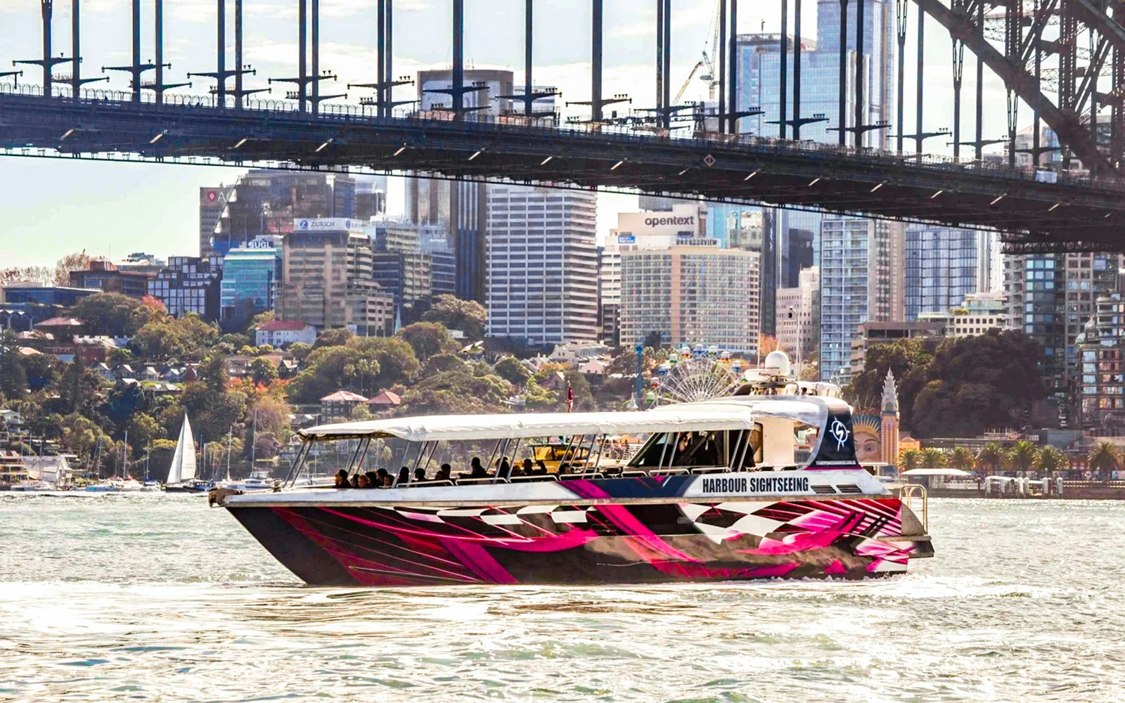 Sydney Harbour cruise boat passing by the Sydney Opera House and Harbour Bridge.