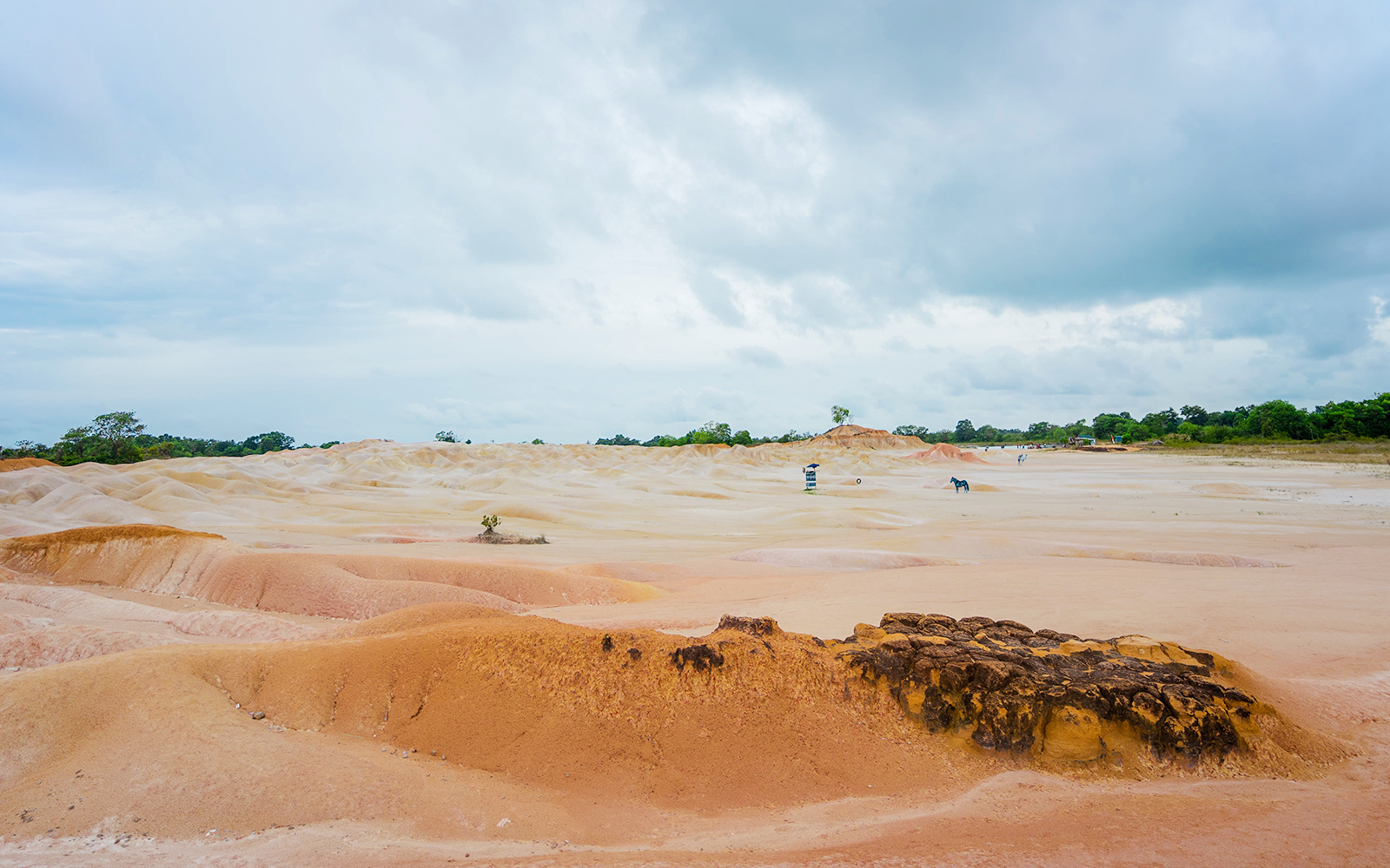 Bintan Mini Desert with sandy dunes under a cloudy sky, Indonesia.
