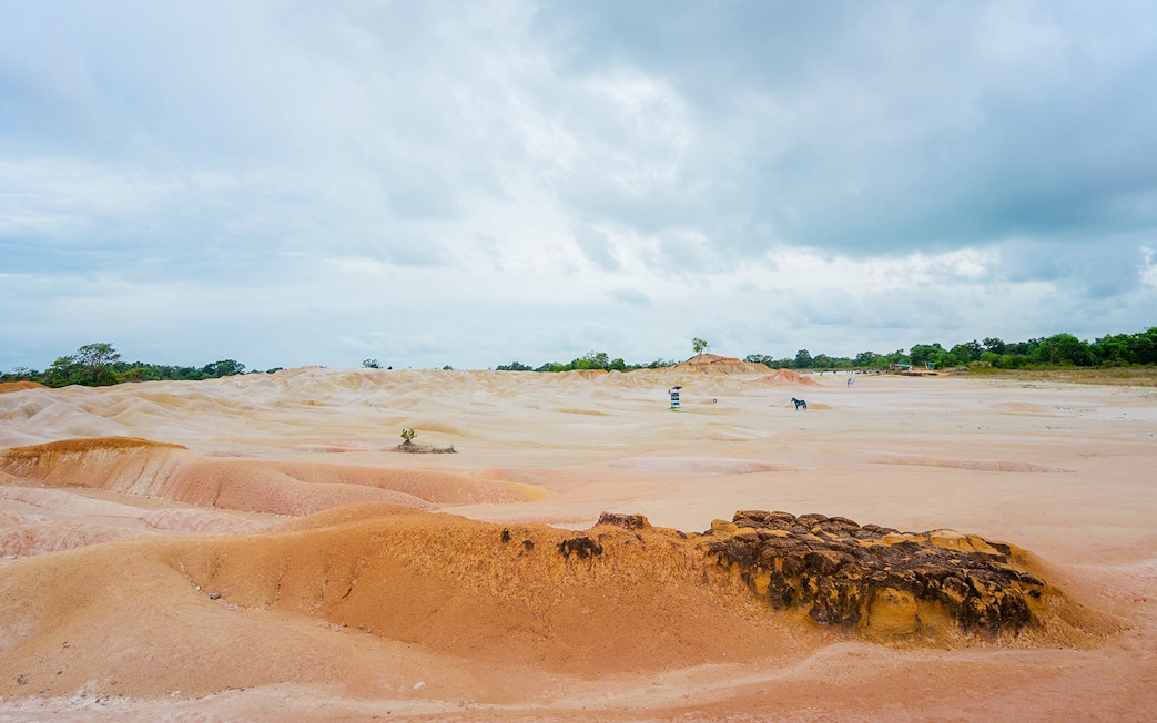 Bintan Mini Desert with sandy dunes under a cloudy sky, Indonesia.