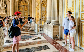 Visitors exploring the ornate interiors of Versailles Palace during a private guided tour.