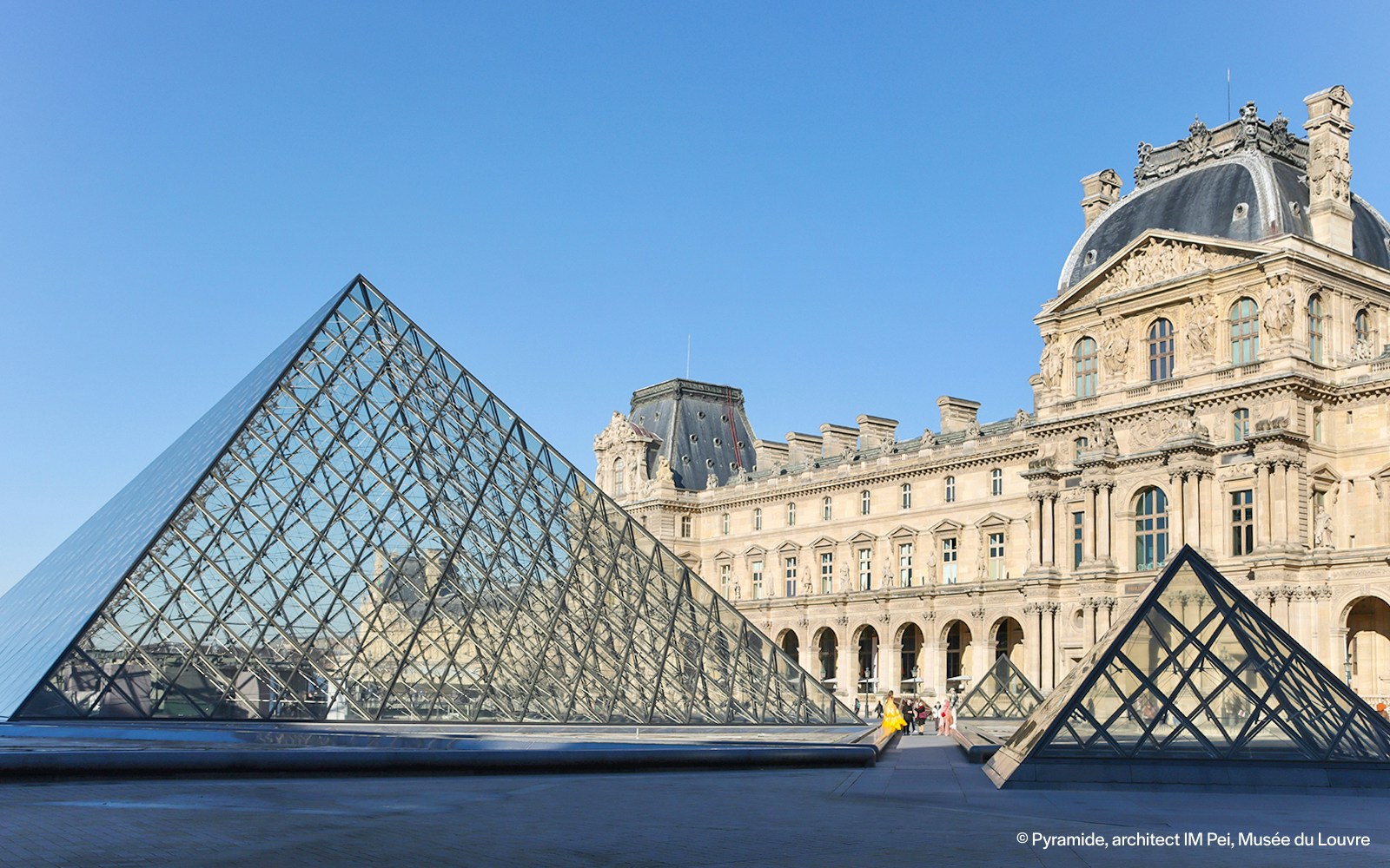 Louvre Museum glass pyramid entrance in Paris, France.