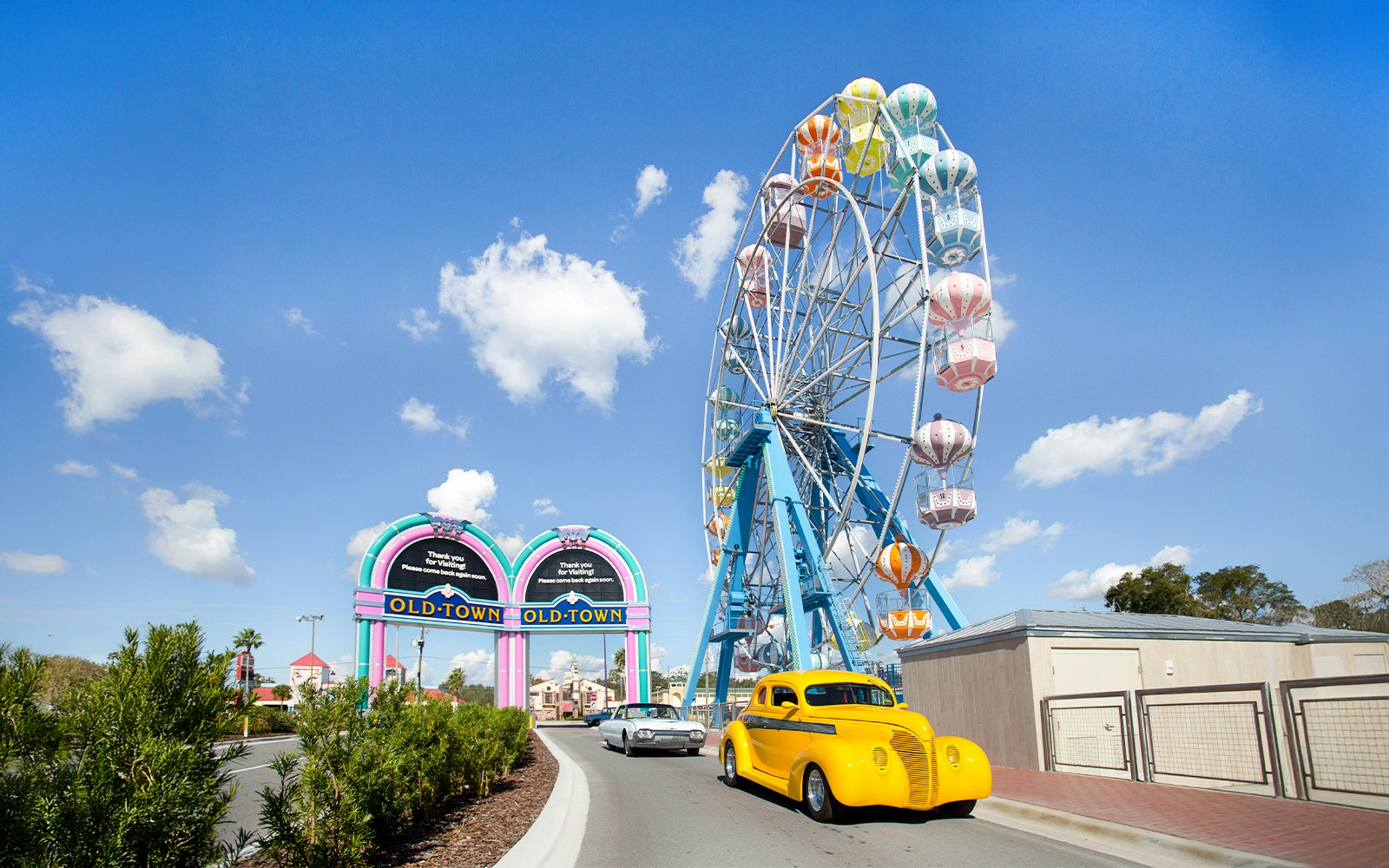 Old Town Ferris Wheel in Orlando with vintage cars on the road.