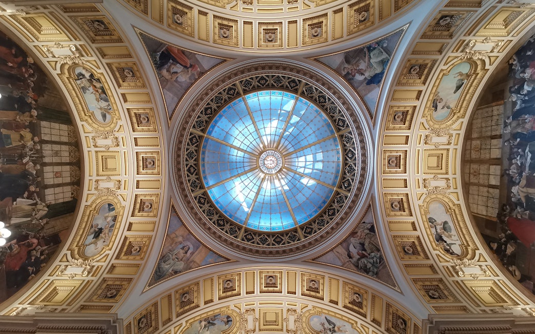 Ceiling of Prague's National Museum with ornate frescoes and a central glass dome.
