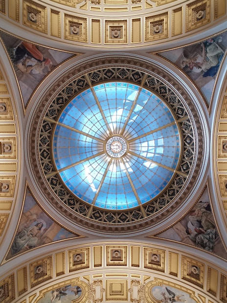 Ceiling of Prague's National Museum with ornate frescoes and a central glass dome.