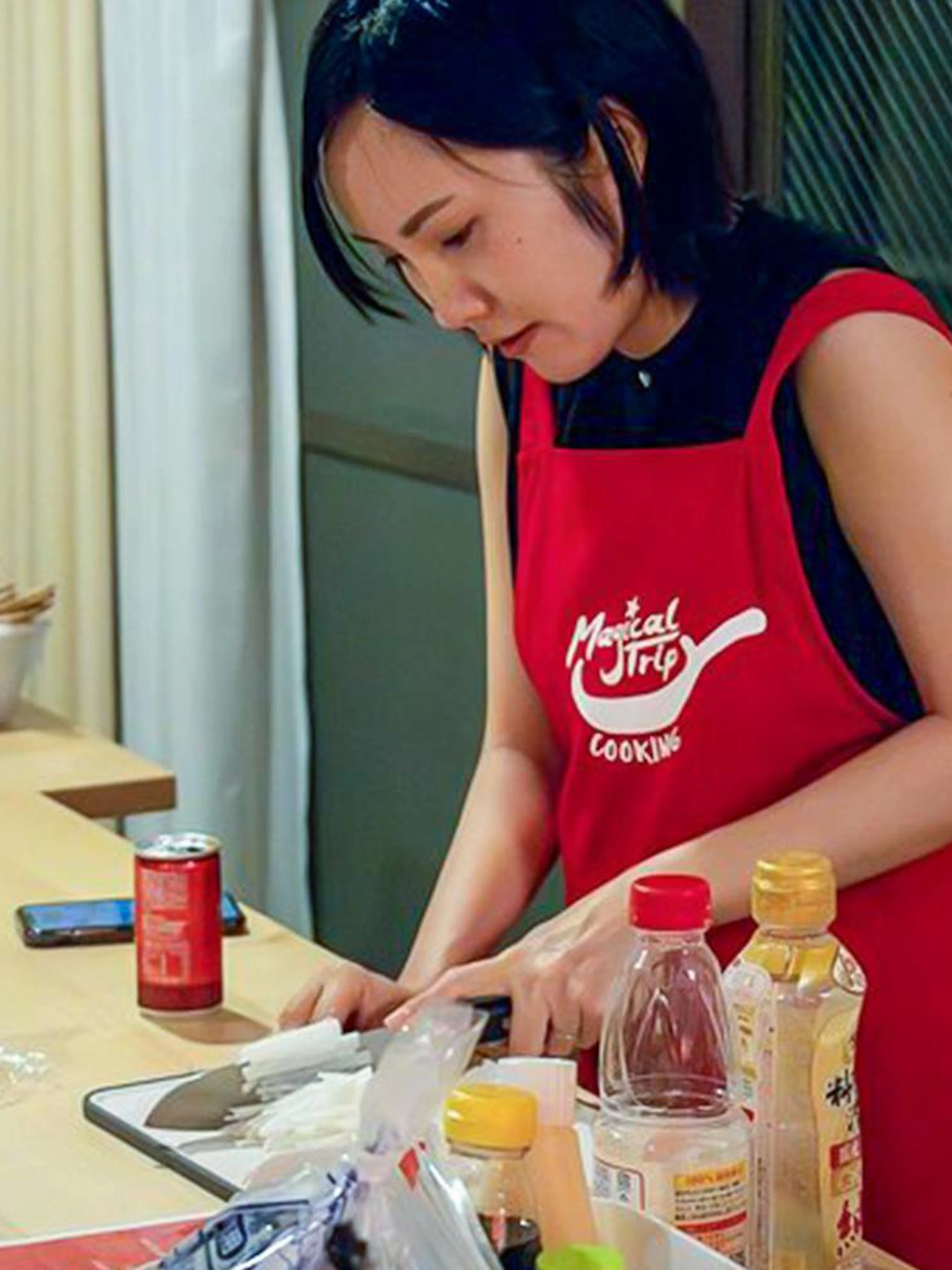 Person preparing ingredients in a Tokyo izakaya-style cooking class kitchen.