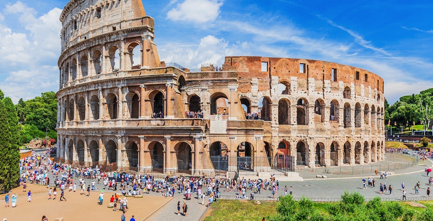 Colosseum in Rome with tourists exploring the ancient amphitheater.