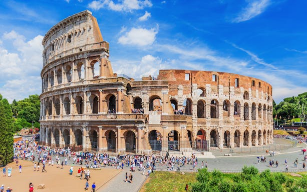 Colosseum in Rome with tourists exploring the ancient amphitheater.