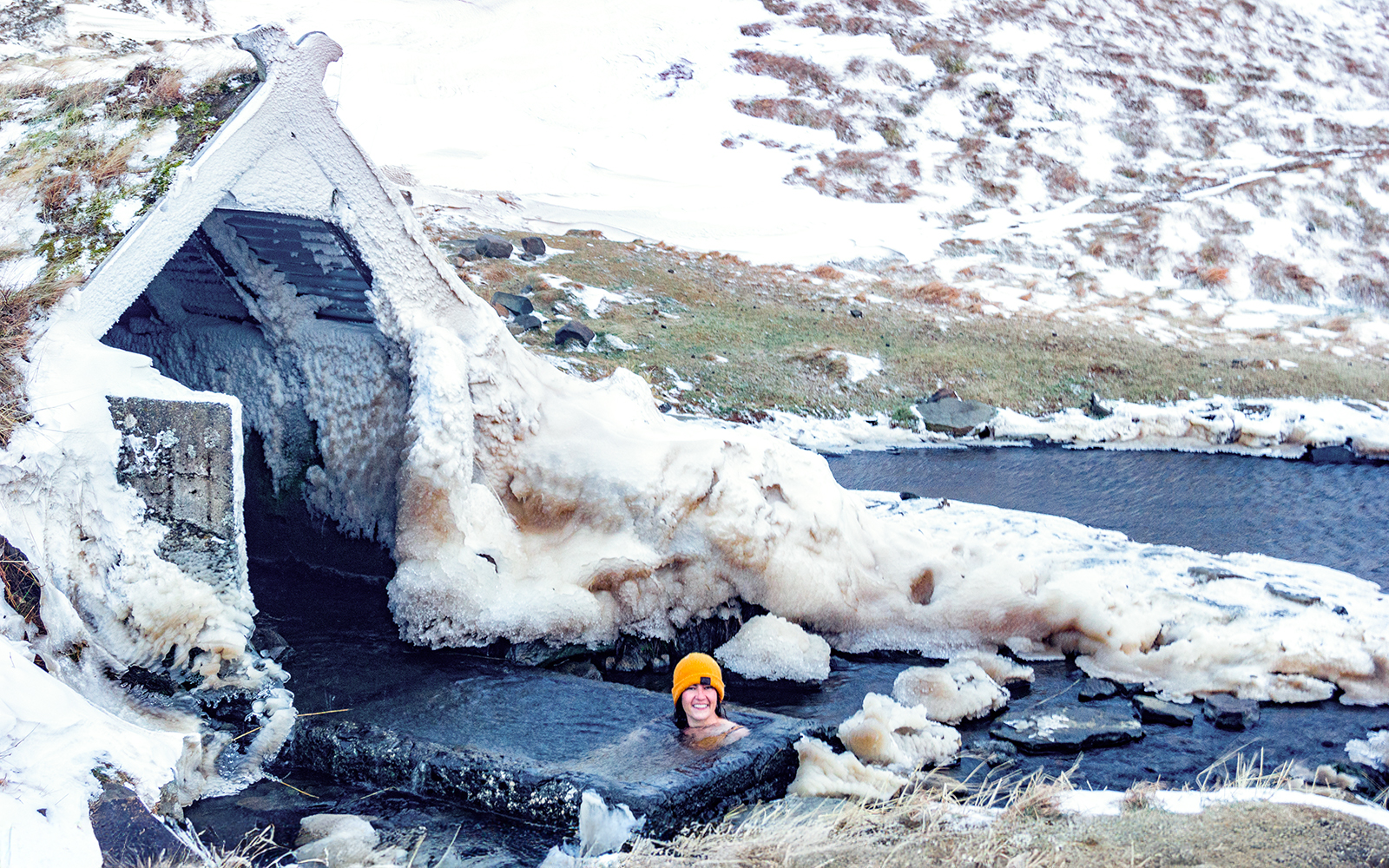 Secret lagoon in Fludir, Iceland with steam rising from hot springs during winter.