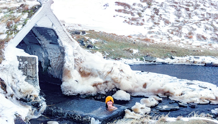 Secret lagoon in Fludir, Iceland with steam rising from hot springs during winter.