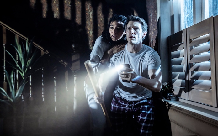 Couple holding flashlight and bat during Paranormal Activity stage performance, Westend.