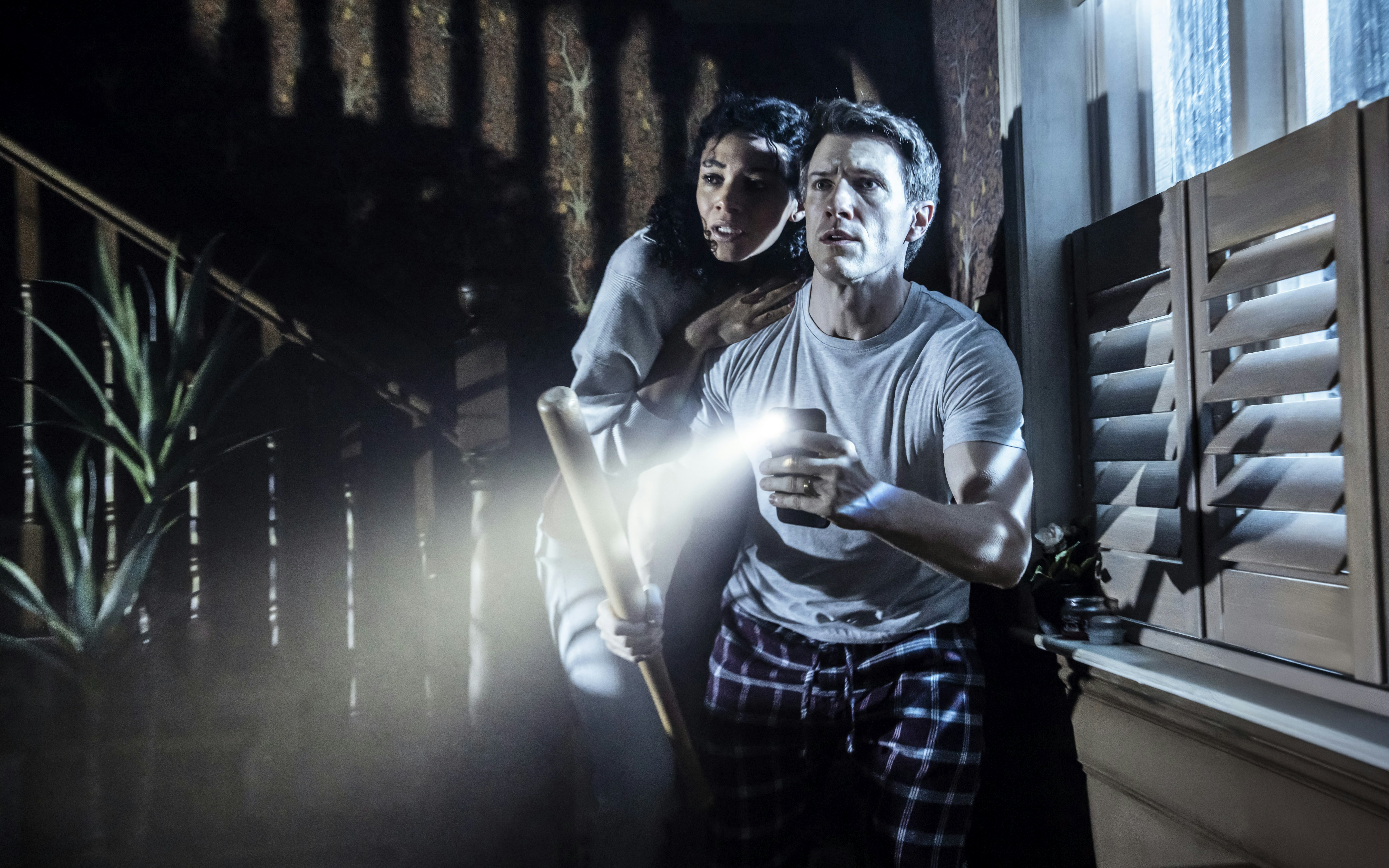 Couple holding flashlight and bat during Paranormal Activity stage performance, Westend.