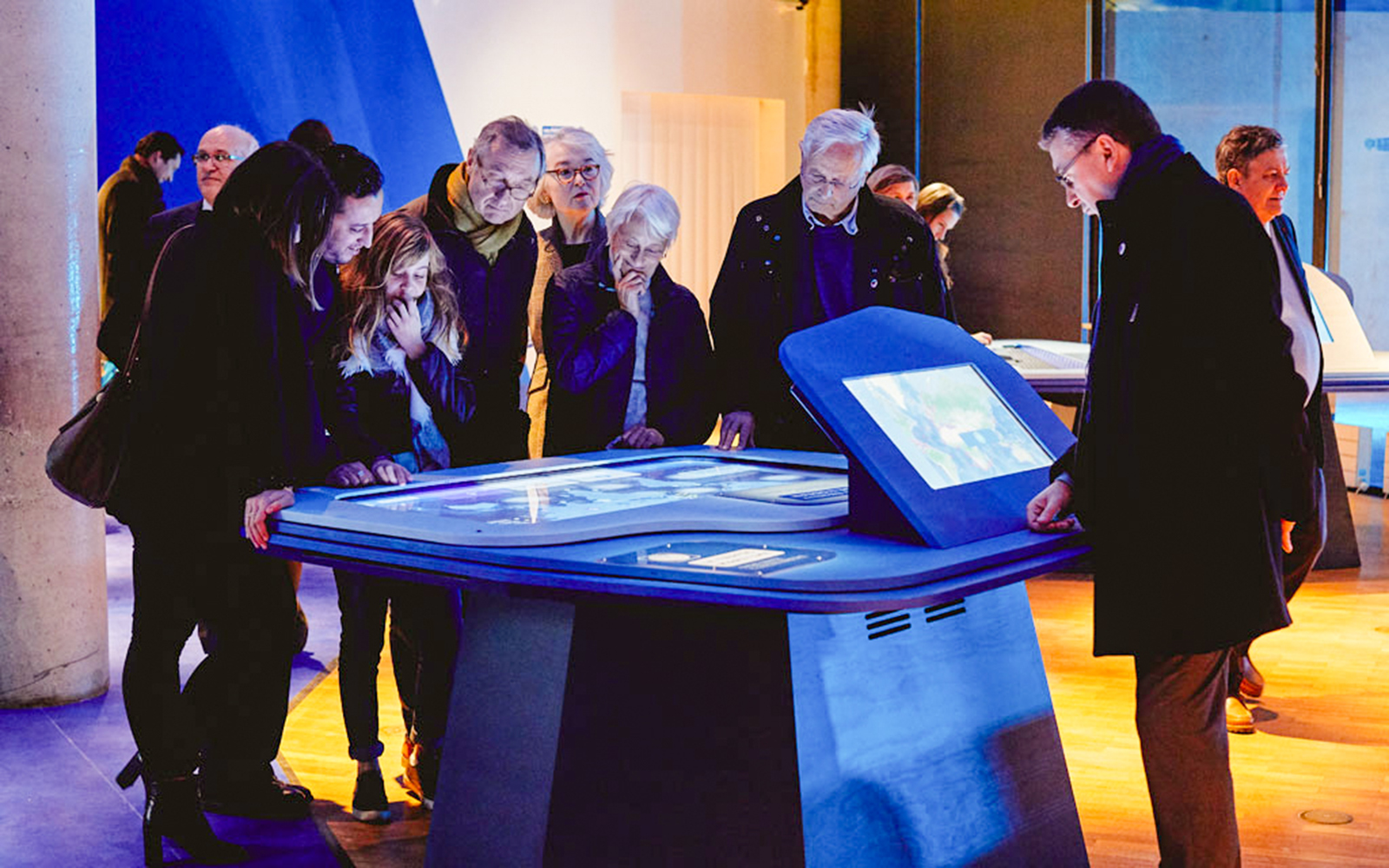 Visitors engaging with interactive display at a museum exhibit.
