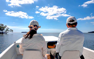 Guests on airboat tour in national park, viewing open water and distant trees.