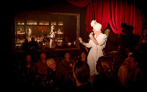 Performer on stage at Miss Behaves: Maverick's Variety Show, engaging audience.