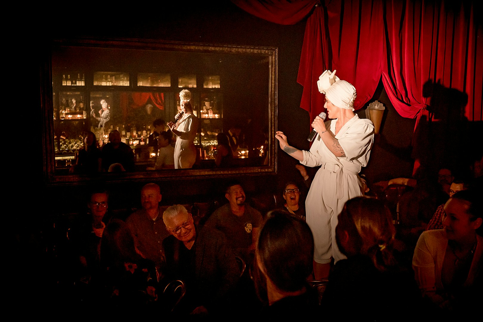 Performer on stage at Miss Behaves: Maverick's Variety Show, engaging audience.