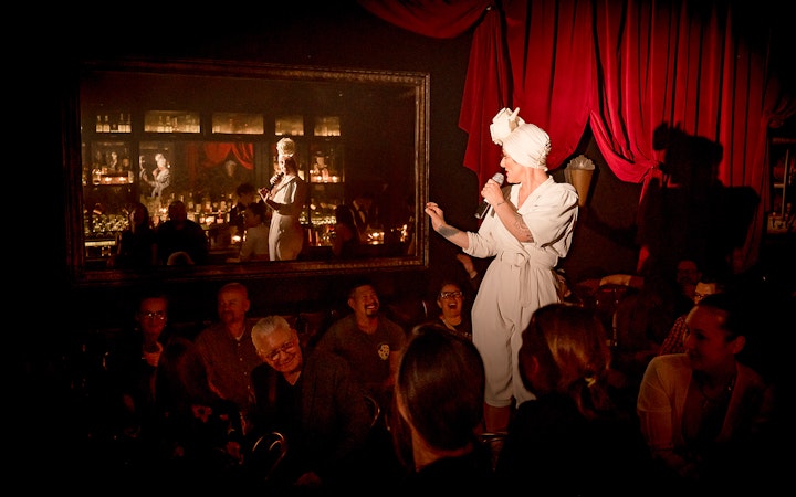 Performer on stage at Miss Behaves: Maverick's Variety Show, engaging audience.