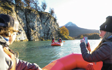 Kayakers on a river with mountains in Tierra del Fuego National Park.