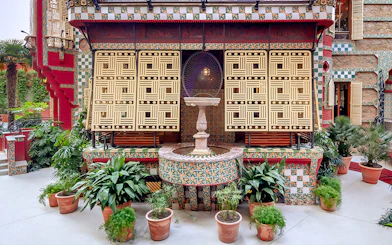 Casa Vicens backyard with decorative tiles, fountain, and potted plants in Barcelona.