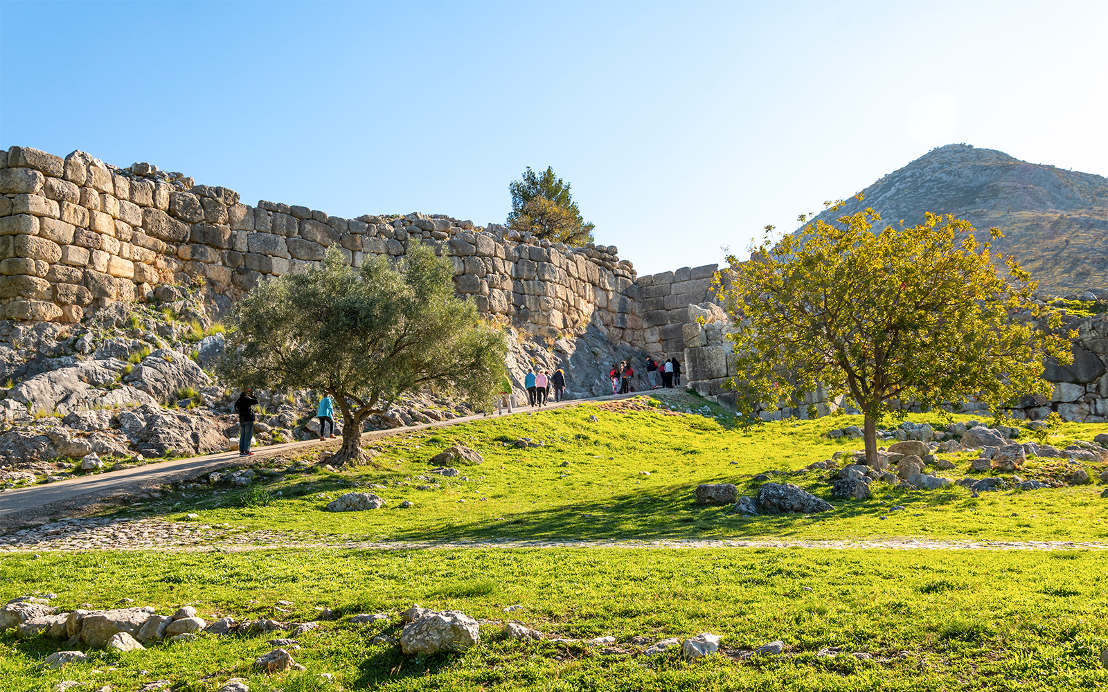 Tourists entering the ancient Lion's Gate at Mycenae, Greece.