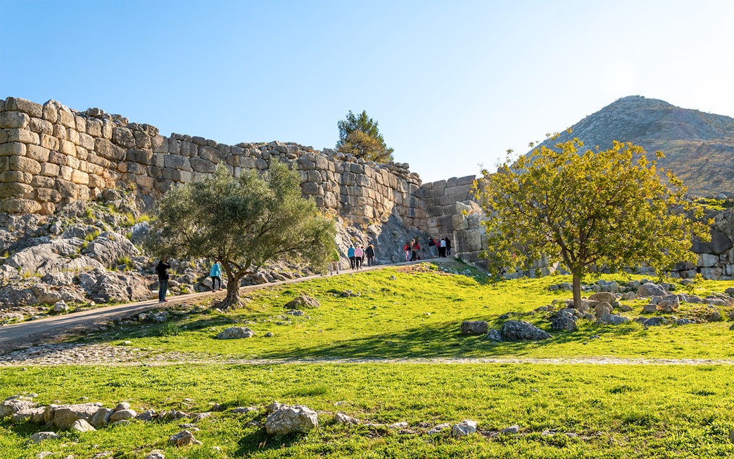 Tourists entering the ancient Lion's Gate at Mycenae, Greece.