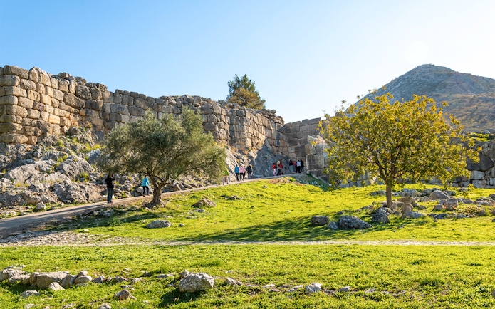 Tourists entering the ancient Lion's Gate at Mycenae, Greece.