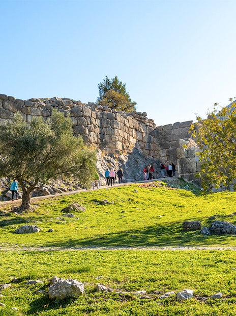 Tourists entering the ancient Lion's Gate at Mycenae, Greece.