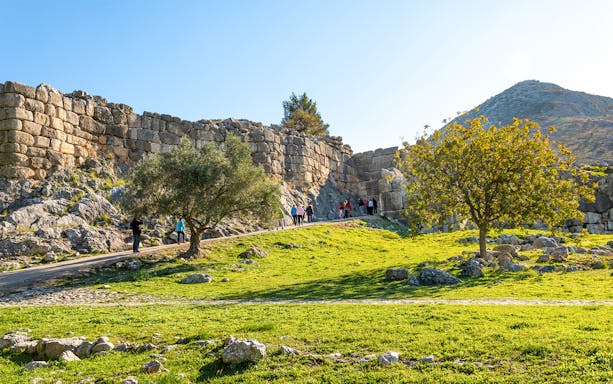 Tourists entering the ancient Lion's Gate at Mycenae, Greece.