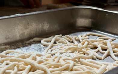 Fresh pasta dough on a floured surface during a cooking class in Siena.