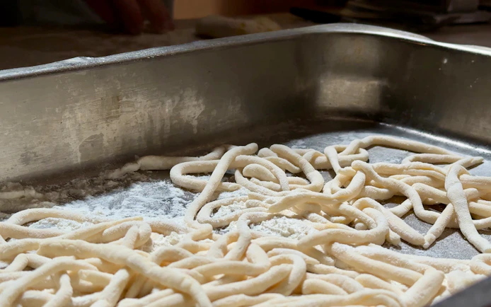 Fresh pasta dough on a floured surface during a cooking class in Siena.
