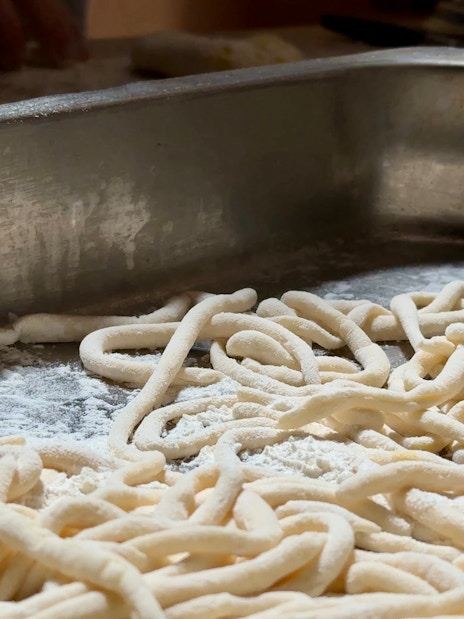 Fresh pasta dough on a floured surface during a cooking class in Siena.