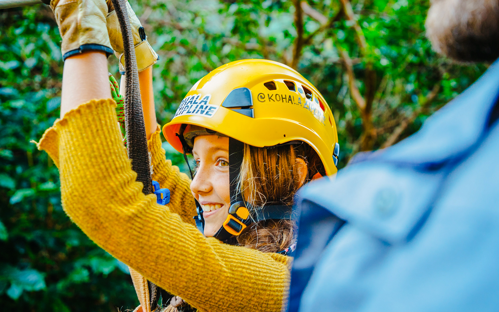 Guest zip lining on Kohala Canopy Adventure, wearing a helmet and harness.