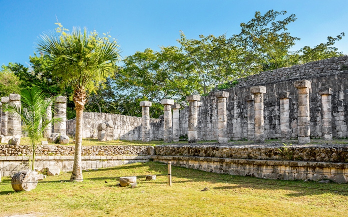 Ancient stone columns at Chichén Itzá during sunrise tour, Yucatán, Mexico.