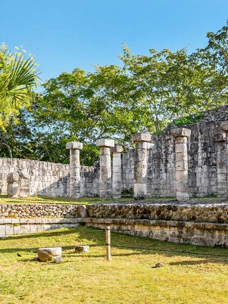 Ancient stone columns at Chichén Itzá during sunrise tour, Yucatán, Mexico.