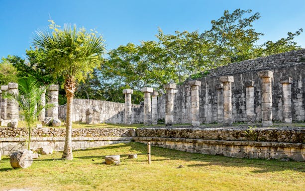 Ancient stone columns at Chichén Itzá during sunrise tour, Yucatán, Mexico.