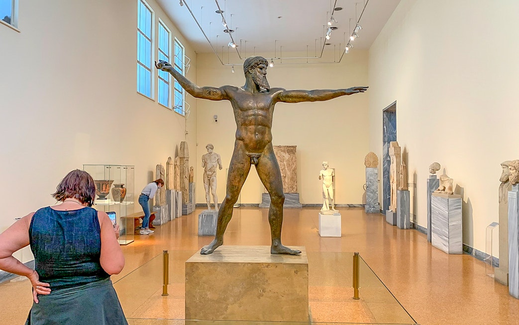 Guests viewing ancient sculptures inside National Archaeological Museum.