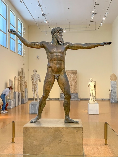 Guests viewing ancient sculptures inside National Archaeological Museum.