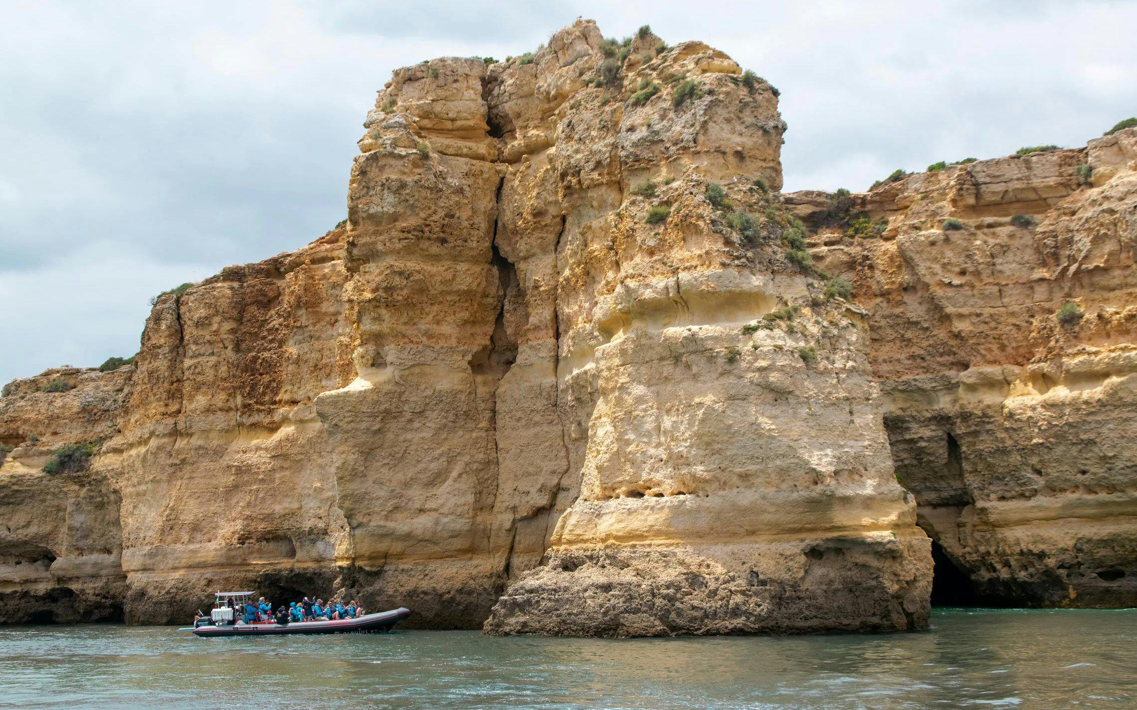 Tourist boat approaching Benagil Caves in Algarve, Portugal.