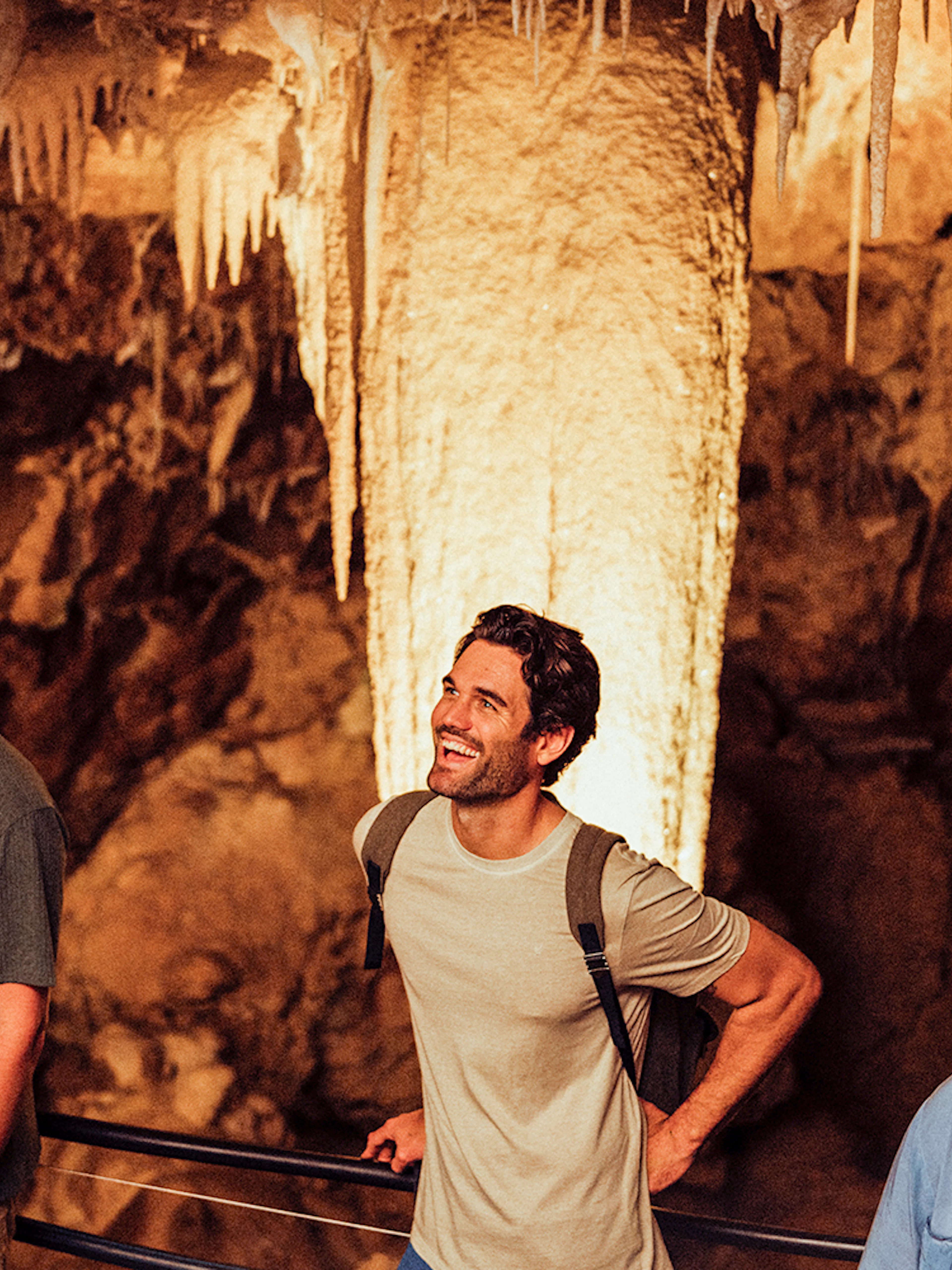 Visitors exploring stalactites in Ngilgi Cave, Australia.